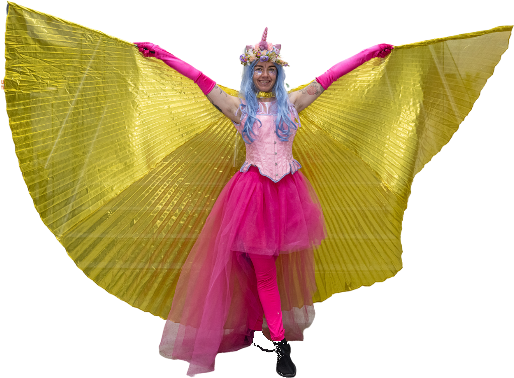 A performer in a unicorn costume with a pink horn and large gold wings.